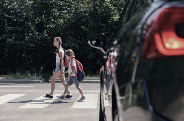 Enfants sur un passage pour piétons devant un véhicule